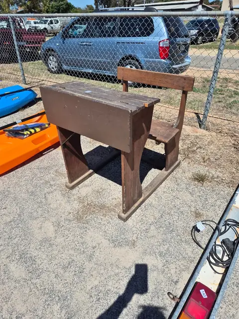 An old timber school desk with an attached bench seat.